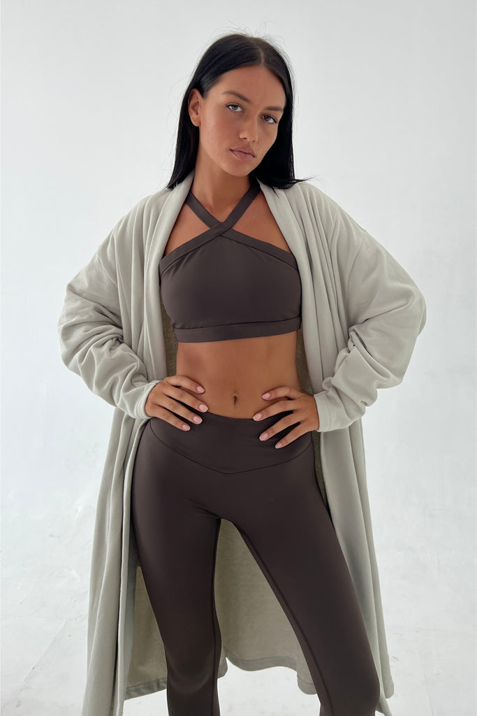Dark brown sports bra top and leggings showcase the woman's active lifestyle.